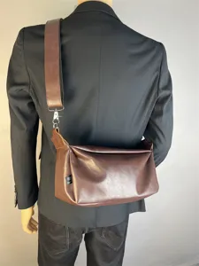 Detailed view of retro brown leather crossbody messenger bag worn across back, stylish daily wear.