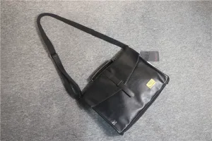 Vista dettagliata della borsa a tracolla nera da uomo con patta ed etichetta logo.