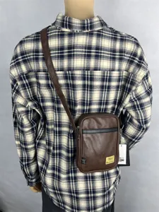 Detailed view of brown PU leather vertical crossbody bag worn on back, showing strap and texture.