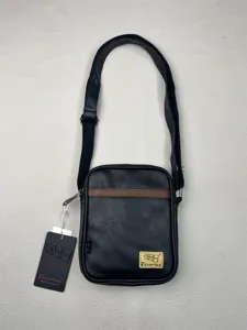 Black vertical crossbody bag detail shot, PU leather messenger bag with brown accent stripe.