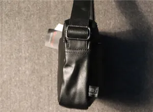Detail view of threebox men's black leather shoulder bag with adjustable metal buckle strap.