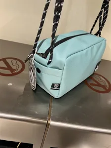 Detailed view of casual canvas crossbody bag in light blue with black and white straps.