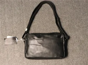 Black mens shoulder bag casual crossbody messenger bag with adjustable strap and tag.