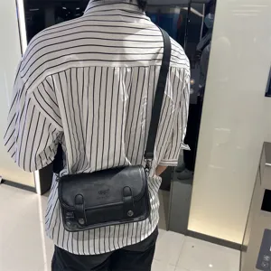 Vista dettagliata della borsa a tracolla nera da uomo, design con patta indossata sul retro.