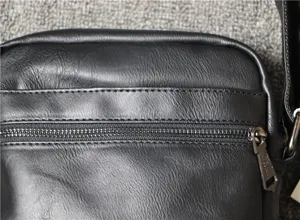 Men black soft leather vertical shoulder bag detailed view featuring front zipper pocket