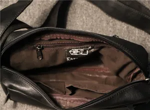 Detailed view of the black men's leather shoulder bag showing inner lining and pockets.