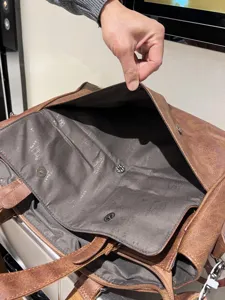 Dettaglio interno di borsa ventiquattrore da lavoro in pelle vintage marrone con scomparto.