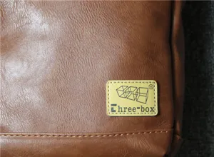 Men's retro brown shoulder bag detail shot featuring soft leather texture and branded label.