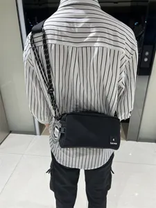 Black canvas crossbody bag detail view, casual shoulder messenger bag for daily commute.