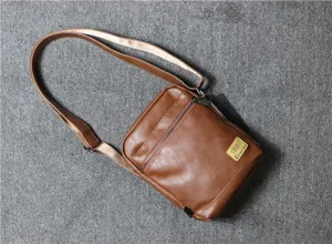 Detail view of the brown leather vintage vertical men messenger bag with adjustable strap.