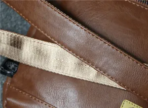 Close-up detail of men's brown vintage leather shoulder bag strap and texture design.