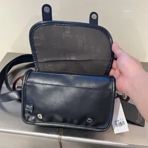 Borsa a tracolla cilindrica in pelle nera da uomo, patta, bottone magnetico e stampa interna.