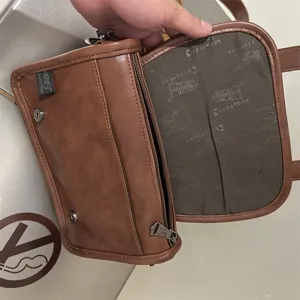 Borsa a tracolla da uomo in pelle marrone con patta e tasca con zip, dettaglio.