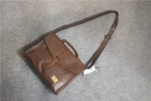 Vista dettagliata della borsa a tracolla in pelle marrone con patta anteriore, manico e cinghia.