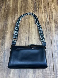 Vue détaillée du sac bandoulière en cuir noir doté d'une élégante sangle à motif géométrique.