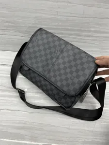 Gros plan détaillé d'un sac bandoulière à motif damier noir et gris avec sangle réglable.