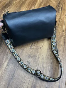 Sac bandoulière homme en cuir souple noir avec large sangle brodée de style ethnique.