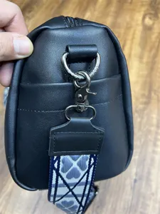 Sac bandoulière en cuir pour homme détail montrant quincaillerie et sangle motif gros plan.