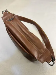 Brown leather crossbody bag detail, vintage men shoulder bag zipper pocket close up view.