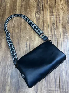 Vue détail du sac messager en cuir souple pour homme avec large bandoulière géométrique usage.