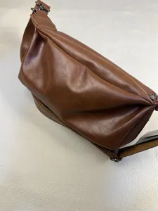 Retro brown leather sling bag for men, casual crossbody croissant bag with adjustable strap.