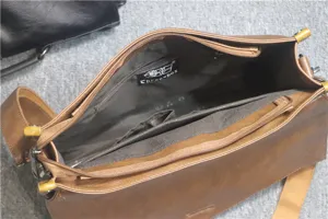 Vista dettagliata dell'interno della valigetta in pelle marrone con tasche con cerniera.