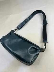 Minimalist retro leather crossbody bag detail view, dark green men casual shoulder bag.