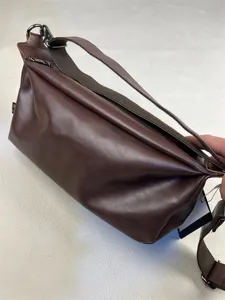 Detailed view of this vintage brown leather messenger bag for men, featuring durable canvas strap.