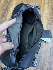 Sac bandoulière souple décontracté pour homme avec sangle à motifs et multiples poches intérieures.