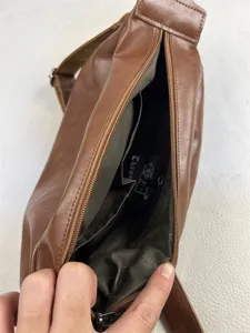 Interior detail view of a brown vintage men casual crossbody bag showcasing inner pockets.