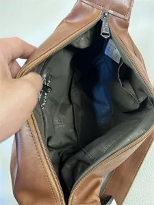 Brown leather vintage men crossbody shoulder bag interior detail showing lining and zipper.