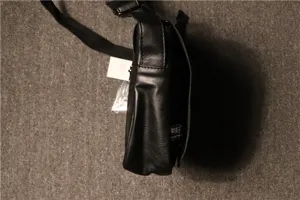 Black vintage men messenger bag side detail showcasing PU leather texture, flap and strap.