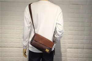Vista dettagliata della borsa a tracolla vintage in marrone indossata da un modello.