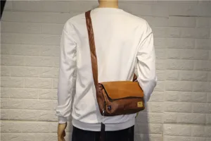 Borsa a tracolla in pelle marrone dettaglio indossato dal modello, stile vintage uomo.