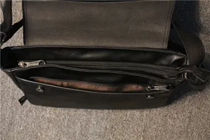 Detail view of black leather messenger bag, interior zipper compartments and flap design.