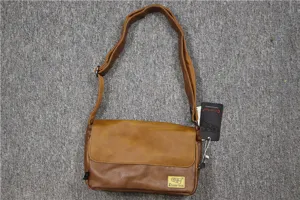 Borsa a tracolla retrò in tela marrone dettaglio con patta e tracolla regolabile.