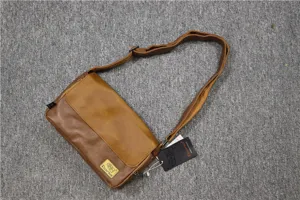Vista dettagliata della borsa a tracolla in pelle marrone, stile rétro con patta.