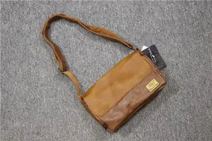 Primo piano della borsa a tracolla vintage in pelle marrone con patta e cinturino.