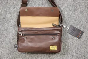 Primo piano dettagliato della borsa a tracolla in pelle marrone con tasche con cerniera.