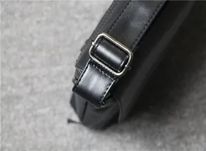 Black leather shoulder bag detail shot showing the metal adjustable strap buckle clearly.