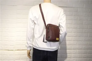 Detailed view of the brown vertical men's crossbody bag worn, showing casual style and strap.