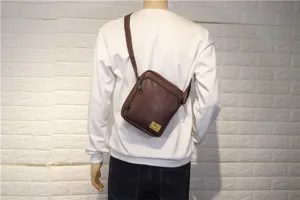 Detail shot of brown leather crossbody bag worn on mannequin, showing adjustable strap design.