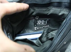 Men black leather shoulder bag interior detail showing zipper pocket and brand label.