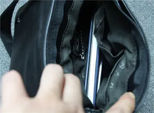 Interior detail shot of men leather shoulder bag showing multi compartments and lining.