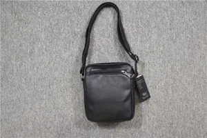 Black vertical shoulder bag detail featuring leather texture and secure front zipper pocket.