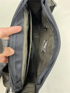 Detailed view of the nylon crossbody bag interior with multiple practical zipper pockets.