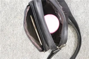 Detail shot of men vertical black leather shoulder bag with multi zip compartments capacity