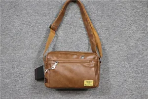 Detail view of brown PU leather messenger bag featuring durable zipper pockets and adjustable strap.