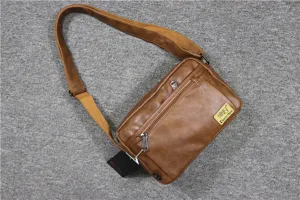Detail view of the brown soft leather messenger bag with adjustable strap and zipper pockets.