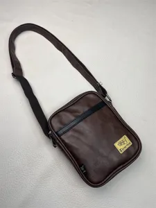 Detail shot of the brown PU leather shoulder crossbody bag featuring contrasting black strap trim.